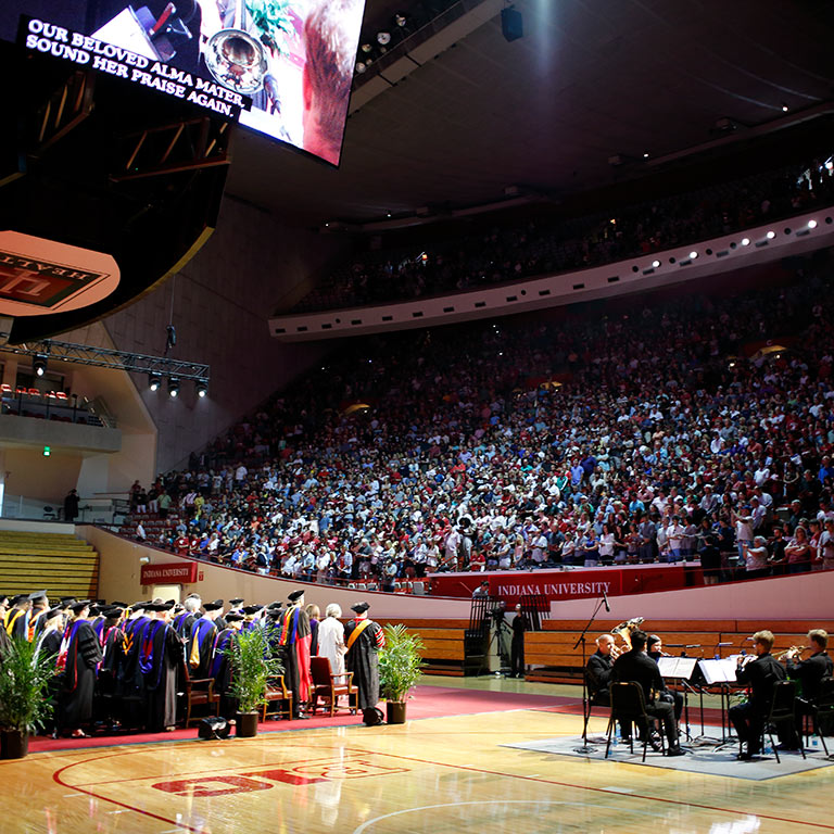 Faculty stand while looking at the crowd for Freshman Induction.